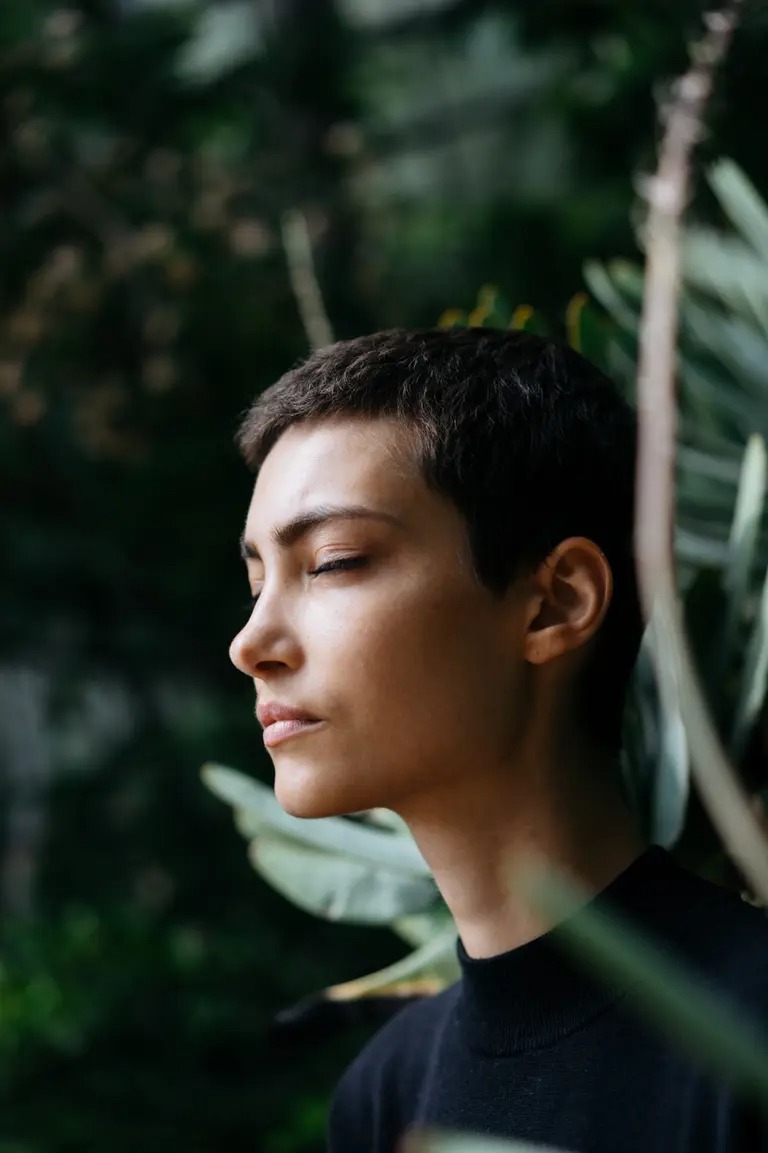 Woman with eyes closed in peaceful natural setting